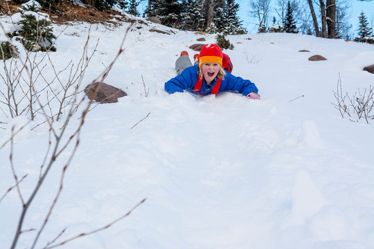 A girl sliding down a snow slope in the San Juan National Forest, Durango, Colorado.