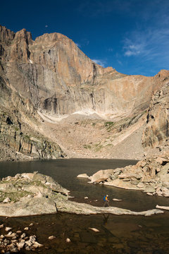 A man hiking along a lake,   Rocky Mountain National Park, Estes Park, Colorado.