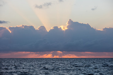 A stunning sunrise illuminates clouds drifting above the Caribbean Sea.