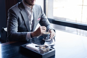 Business man drinking coffee in a cafe - coffee time.