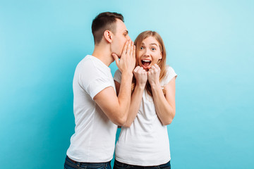 A man whispers in his ear to a woman, telling her something secret, good news