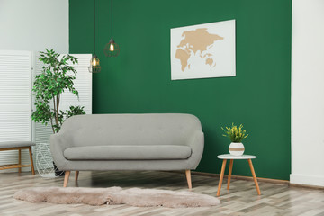 Modern interior with comfortable sofa near green wall