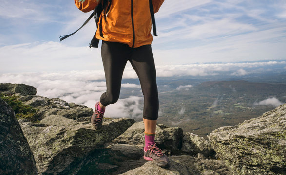 Woman hiking on a rocky ridgeline in New England.