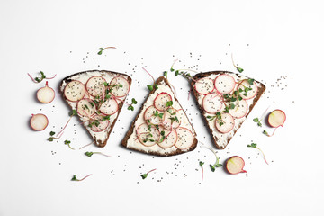 Tasty toasts with radishes, sprouts and chia seeds on white background, top view