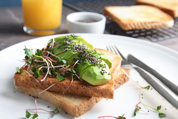 Tasty toasts with avocado, sprouts and chia seeds on plate