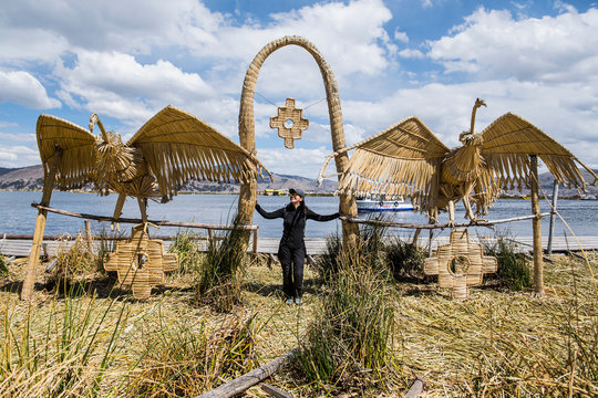 Woman standing at bird sculpture, Titicaca Lake, Puno, Peru