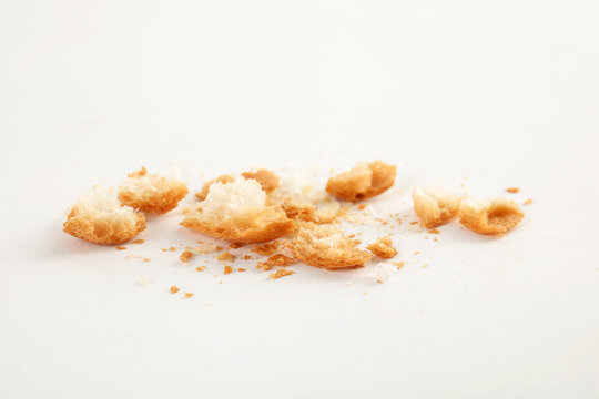 Scattered bread crumbs on white background, closeup