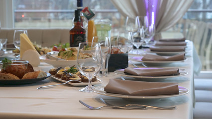 In the beautiful restaurant, the chef (cook) has prepared many different dishes and serves them on the table and many different glasses of wine and other different drinks. Concert of: Banquet, Chef.