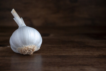Horizontal closeup of white garlic isolated on dark wooden background