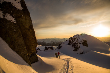Two people enjoy the last light of the day during a backcountry ski tour in the Coast Mountains near Whistler, British Columbia, Canada.