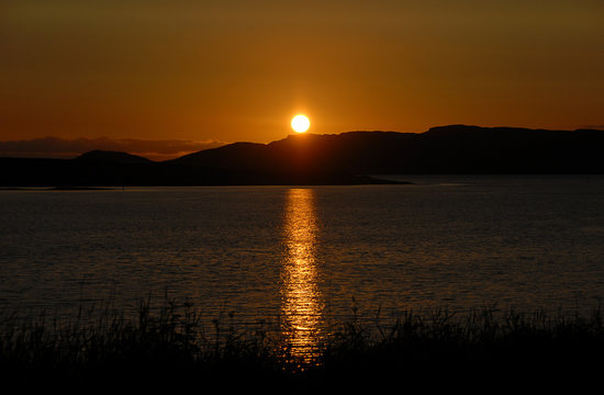 Midnight sun in Nordland, Norge, beautiful reflection in the sea.
