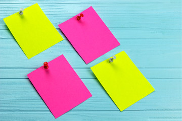 four colorful stickers on needles, blue wooden background