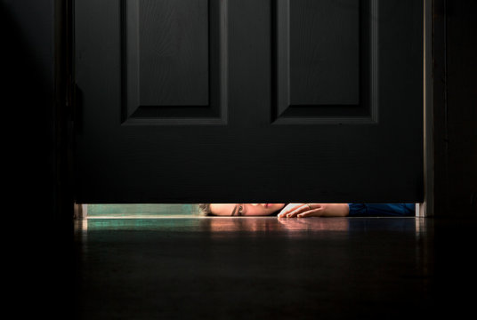Girl peering under door