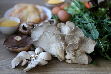Various vegetables, mushrooms, chicken, eggs and grains on a wooden table. Selective focus.