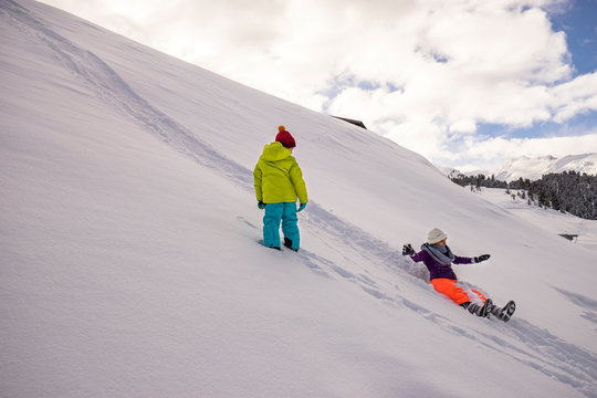 Woman sliding down hill in winter