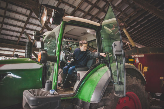 Fototapeta Teenage boy operating tractor on farm, Chilliwack, British Columbia, Canada