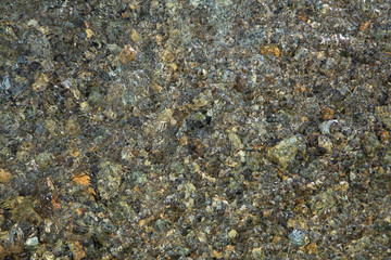 The background of the lake bottom with pebbles under the clear water close-up. Crystal water of Morske Oko Lake