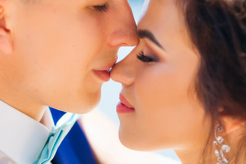 close-up faces of newlyweds. the groom kisses the bride in her n