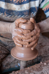 ceramic workshop - the man  makes a pot of clay on a potter's wheel