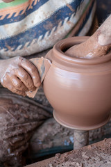 ceramic workshop - the man  makes a pot of clay on a potter's wheel