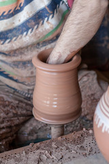 ceramic workshop - the man  makes a pot of clay on a potter's wheel