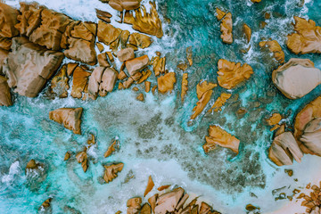 Aerial top view of tropical coastline. Bizarre granite rocks boulders, turquoise azure water. Amazing shore seascape Seychelles La Digue Island