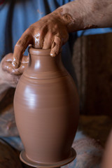 ceramic workshop - the man  makes a pot of clay on a potter's wheel