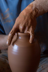 ceramic workshop - the man  makes a pot of clay on a potter's wheel