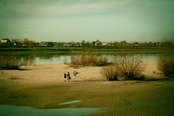 two person man and woman in striped clothes go away a sandy wasteland with balloons past puddles