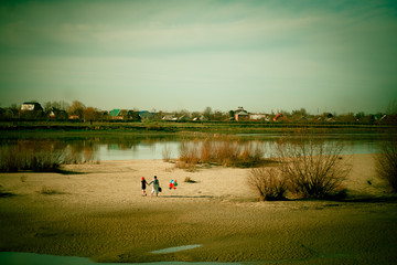 two mims in striped clothes go away a sandy wasteland with balloons and suitcase