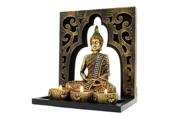 Buddha sculpture with golden color in decorative frame with candles and overall vintage look isolated on white background