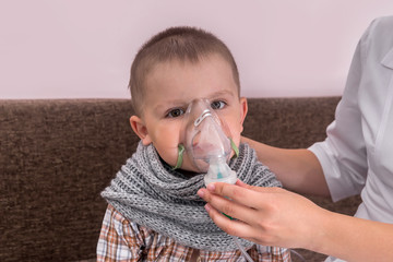 Little boy with nebulizer mask on his face