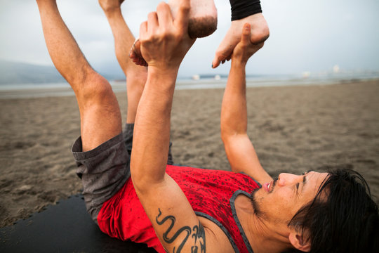 Man and woman doing acroyoga at beach