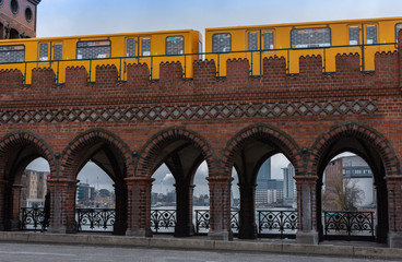Yellow subway cars driving on the Oberbaunum bridge , it links Friedrichshain and Kreuzberg,...