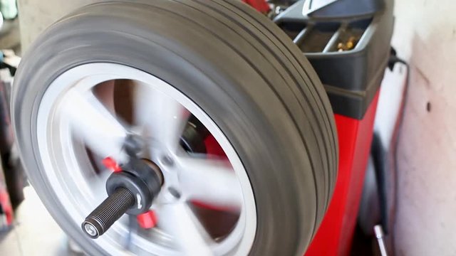 Car wheel balancing in tire service. mechanic repairman balancing automobile car wheel on balancer