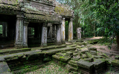 Fototapeta na wymiar Moss covered temple and statue at the Angkor Unesco World Heritage site