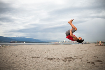 Man doing back flip at beach