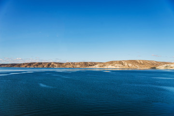 Beautiful landscape photo of turquoise aquamarine lake water and colorful yellow steppes in the mountains of Patagonia, Argentina