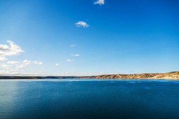 Beautiful landscape photo of turquoise aquamarine lake water and colorful yellow steppes in the mountains of Patagonia, Argentina