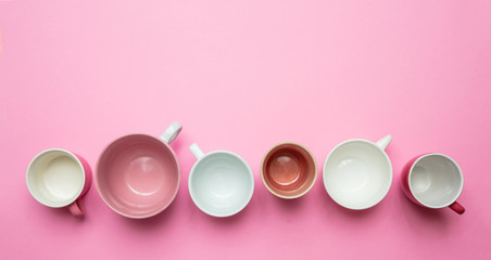 Empty coffee cups white and pink color against pink background, top view