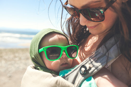 Mother holding baby son at beach