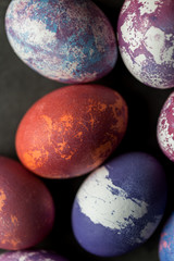 Colorful painted Easter eggs on dark background.