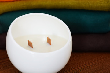 Handmade candle in white moon shape candlestick on wooden table. Front view. Healthy lifestyle concept