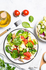 Green salad with chicken and vegetables on white.