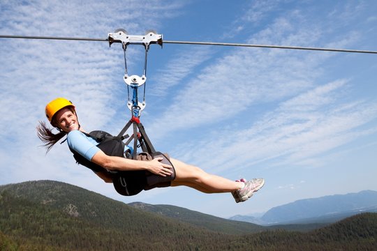 A woman smiles while riding on the longest zip line in Montana at 1,800 foot long and 300 feet off the ground at Whitefish Mountain Resort in Whitefish, Montana.
