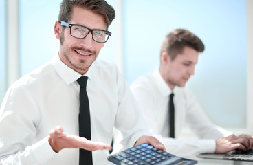 man counting expenses using calculator with laptop on table. Finance calculation concept