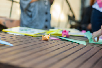 Paper boat on a wooden table, orange boat