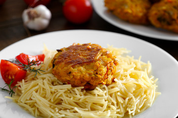 Chickpea cutlet and pasta on a white plate