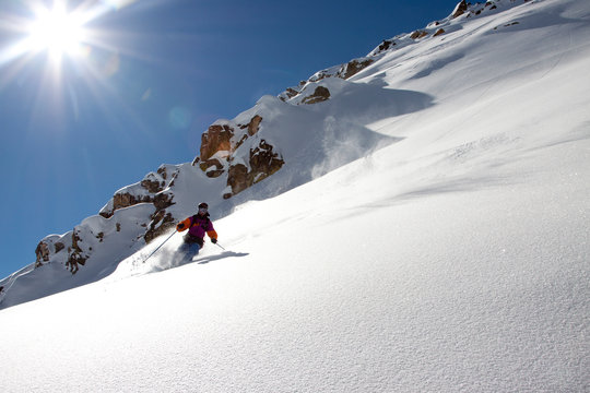 A male backcountry skier makes a turn in fresh powder snow in the Beehive Basin near Big Sky, Montana.