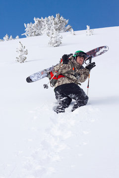 A male skier pauses and does his best ?tiger? face while hiking a bowl on Lone Peak at Big Sky Resort the largest ski resort in the United States by acreage with 5,750 acres, 30 lifts and a vertical drop of 4,350 feet located in Big Sky, Montana.